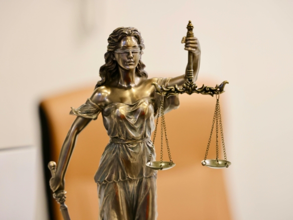 Close-up of Lady Justice statue holding scales, symbolizing justice and fairness.